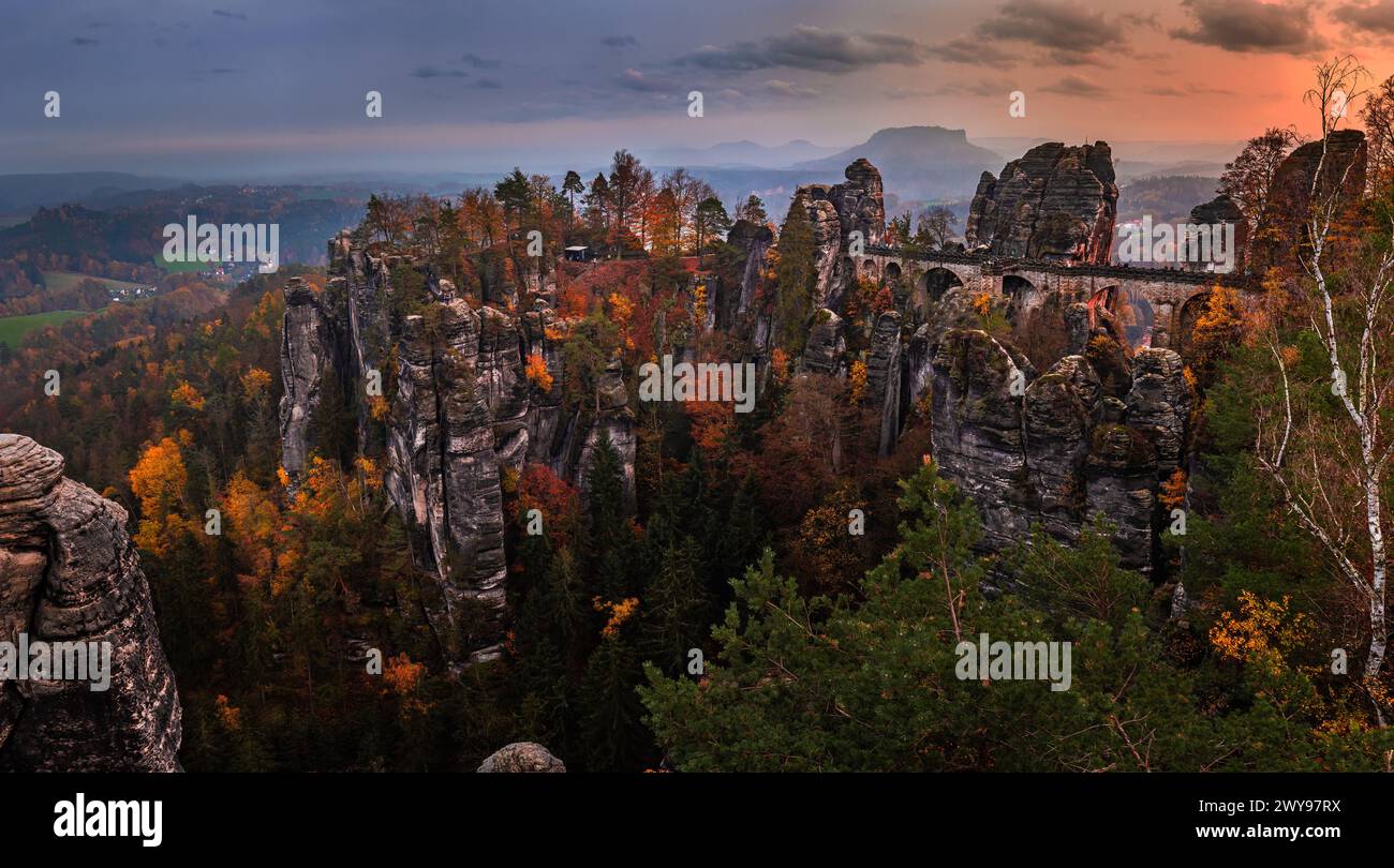 Sassonia, Germania - Vista panoramica del ponte Bastei con un tramonto autunnale soleggiato con fogliame colorato e cielo. Bastei è famosa per la splendida roccia Foto Stock