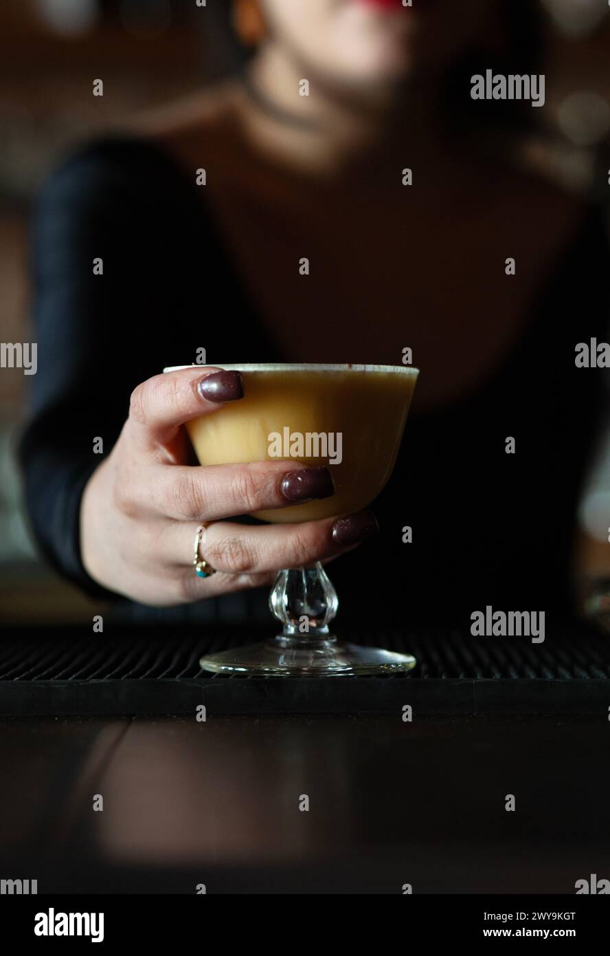 Un barista che consegna bevande miste allo spettatore Foto Stock