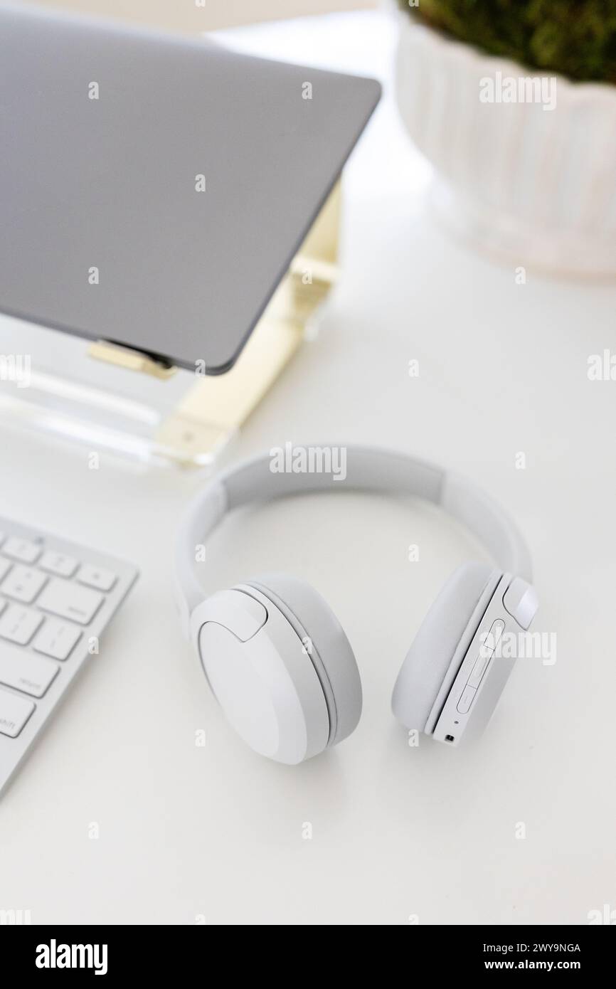 Eleganti cuffie bianche con notebook moderno Foto Stock