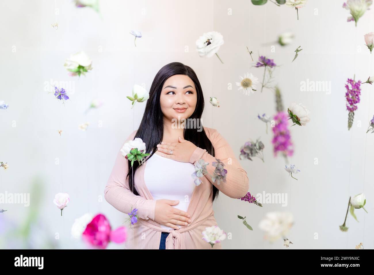 Donna asiatica zen che meditava tra il porpora e il rosa appesi Foto Stock