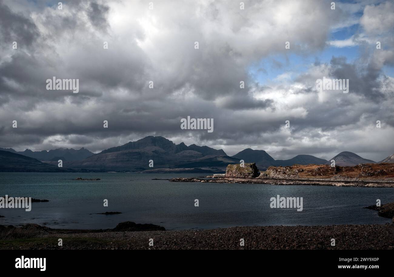 Vista delle rovine del castello di Dunscaith, della costa e delle montagne sull'isola di Skye, in Scozia Foto Stock