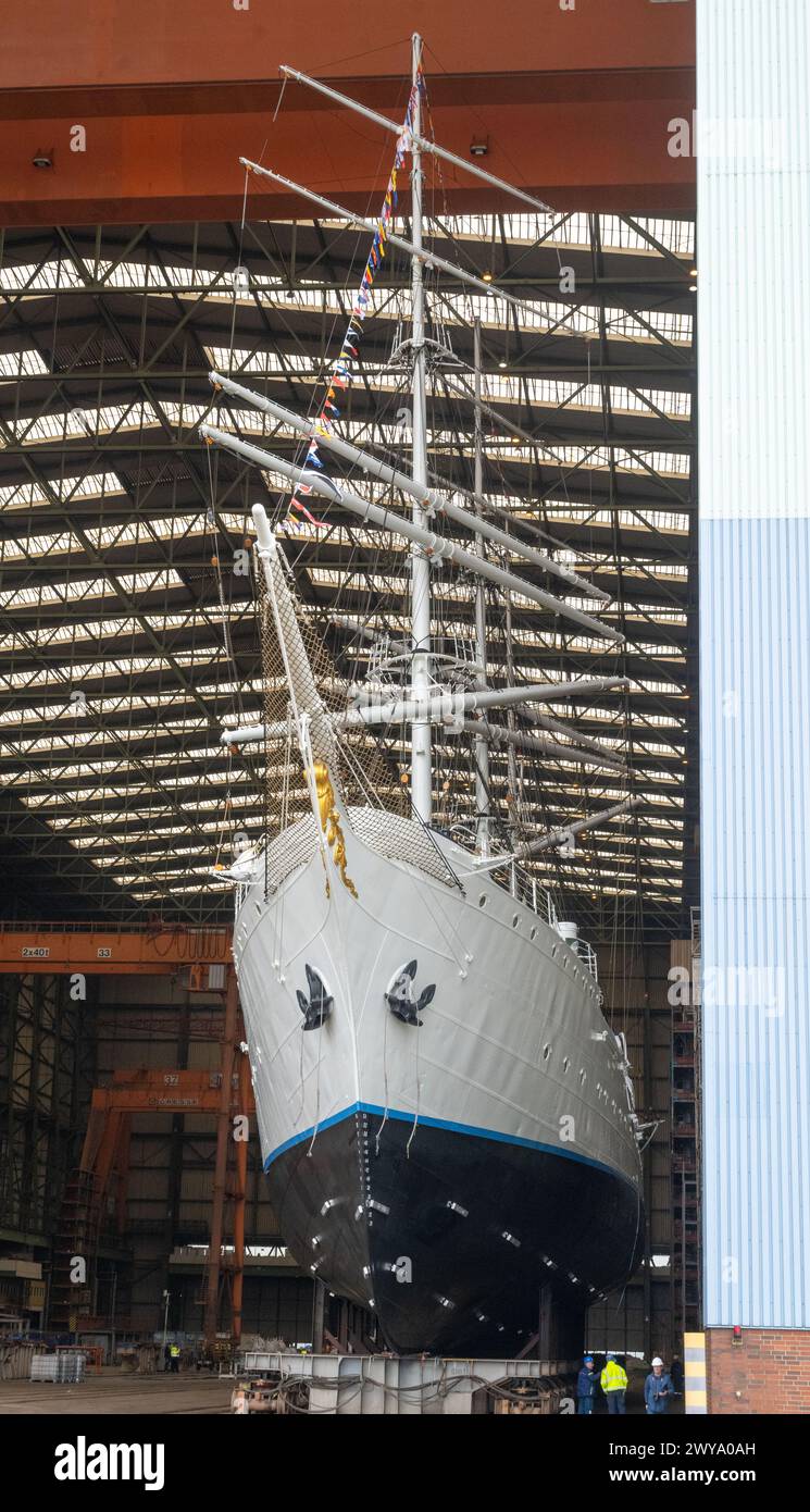 Stralsund, Germania. 5 aprile 2024. Il "Gorch Fock 1" ha lasciato la sala della costruzione navale. Dopo aver trascorso diversi mesi nella grande sala di costruzione navale del cantiere navale Volkswerft di Stralsund, il tradizionale veliero "Gorch Fock 1" di oltre 90 anni è tornato all'aria aperta. Lo stesso giorno, l'ex nave addestratrice a vela ha lasciato la sala del cantiere con un nuovo, scintillante rivestimento bianco di vernice, dove i costruttori navali hanno effettuato estesi lavori di ristrutturazione. In futuro, la nave sarà nuovamente aperta al pubblico come nave museo. Crediti: Stefan Sauer/dpa/Alamy Live News Foto Stock