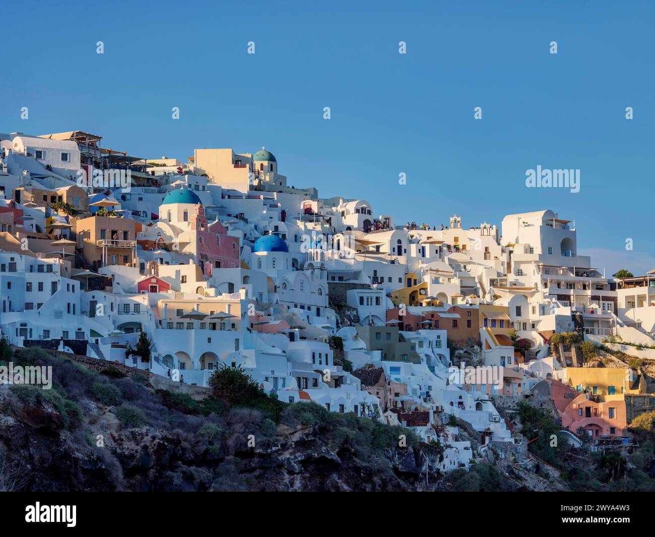 Ammira le chiese a cupola blu della Resurrezione del Signore e di San Spyridon al tramonto, il villaggio di Oia, l'isola di Santorini Thira, le Cicladi, il greco Foto Stock