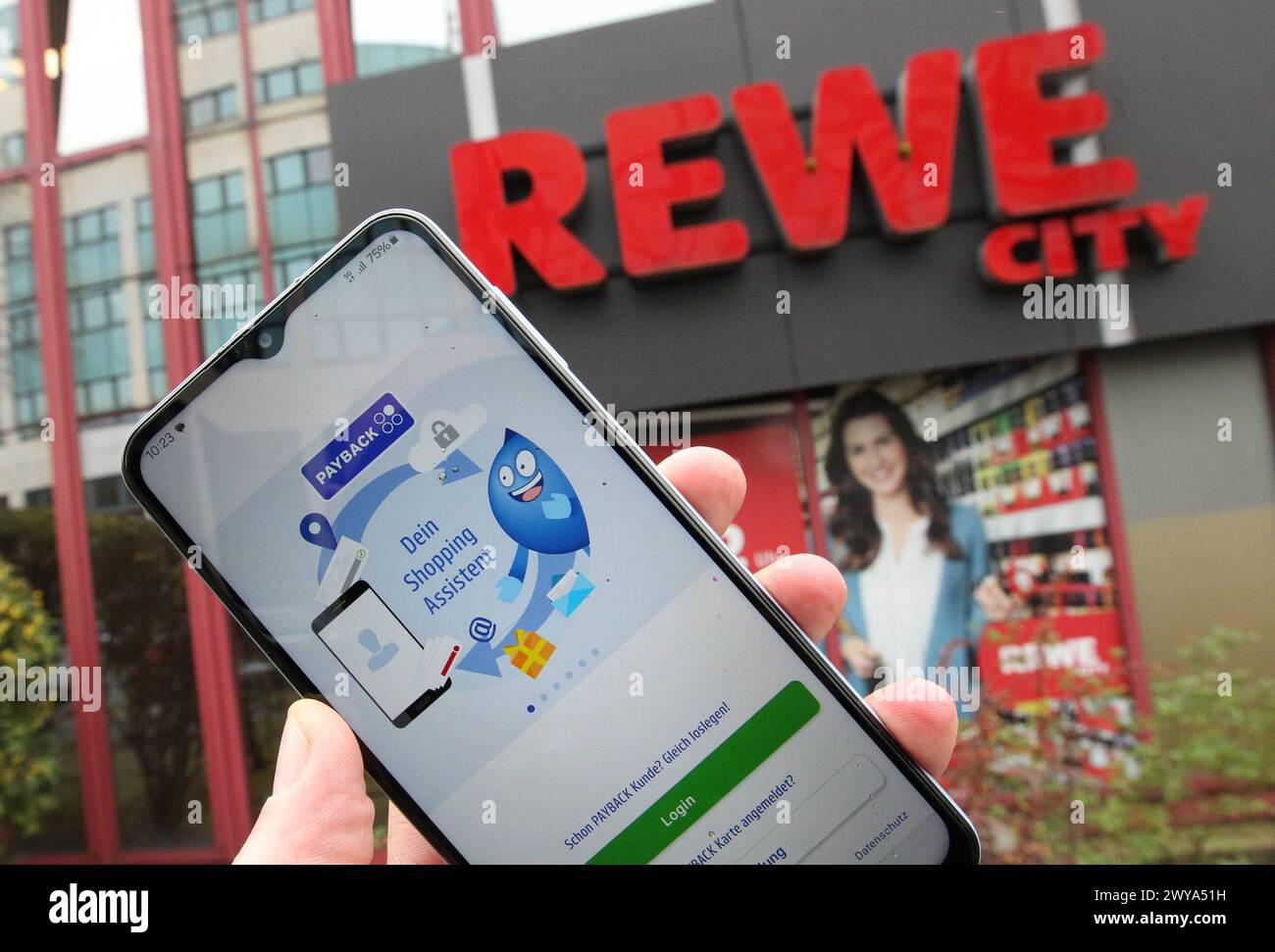 Ein Mann hält vor einer Filiale von Rewe Sein smartphone in der Hand, auf dem die App von Payback geöffnet ist. Simbolo/simbolo foto. Hamm Hamburg *** Un uomo tiene il suo smartphone con l'app Payback aperta di fronte a un negozio Rewe immagine simbolo foto simbolo Hamm Hamburg Foto Stock