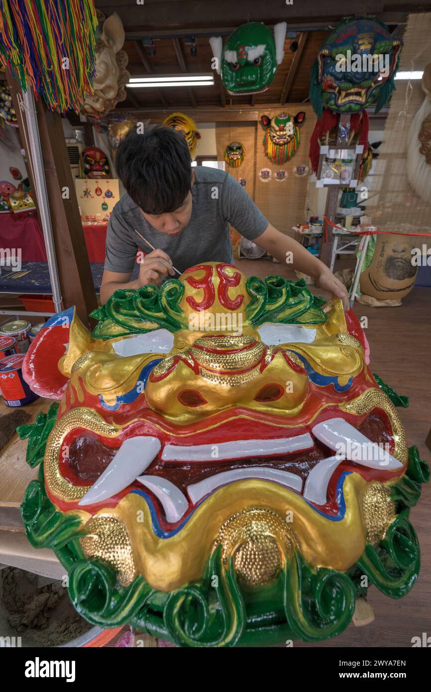 Primo piano di un dipinto artigianale disegni elaborati su una brillante scultura di drago dorato Foto Stock