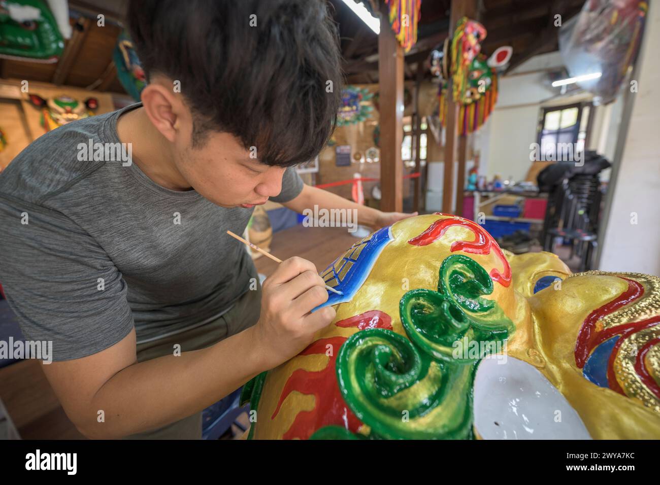 Primo piano di un dipinto artigianale disegni elaborati su una brillante scultura di drago dorato Foto Stock