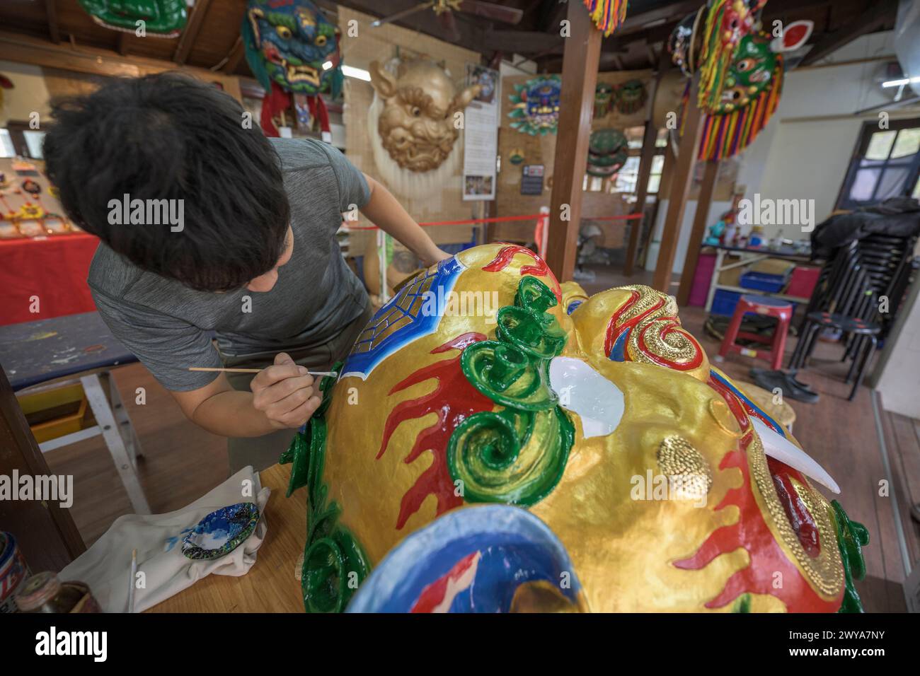 Primo piano di un dipinto artigianale disegni elaborati su una brillante scultura di drago dorato Foto Stock