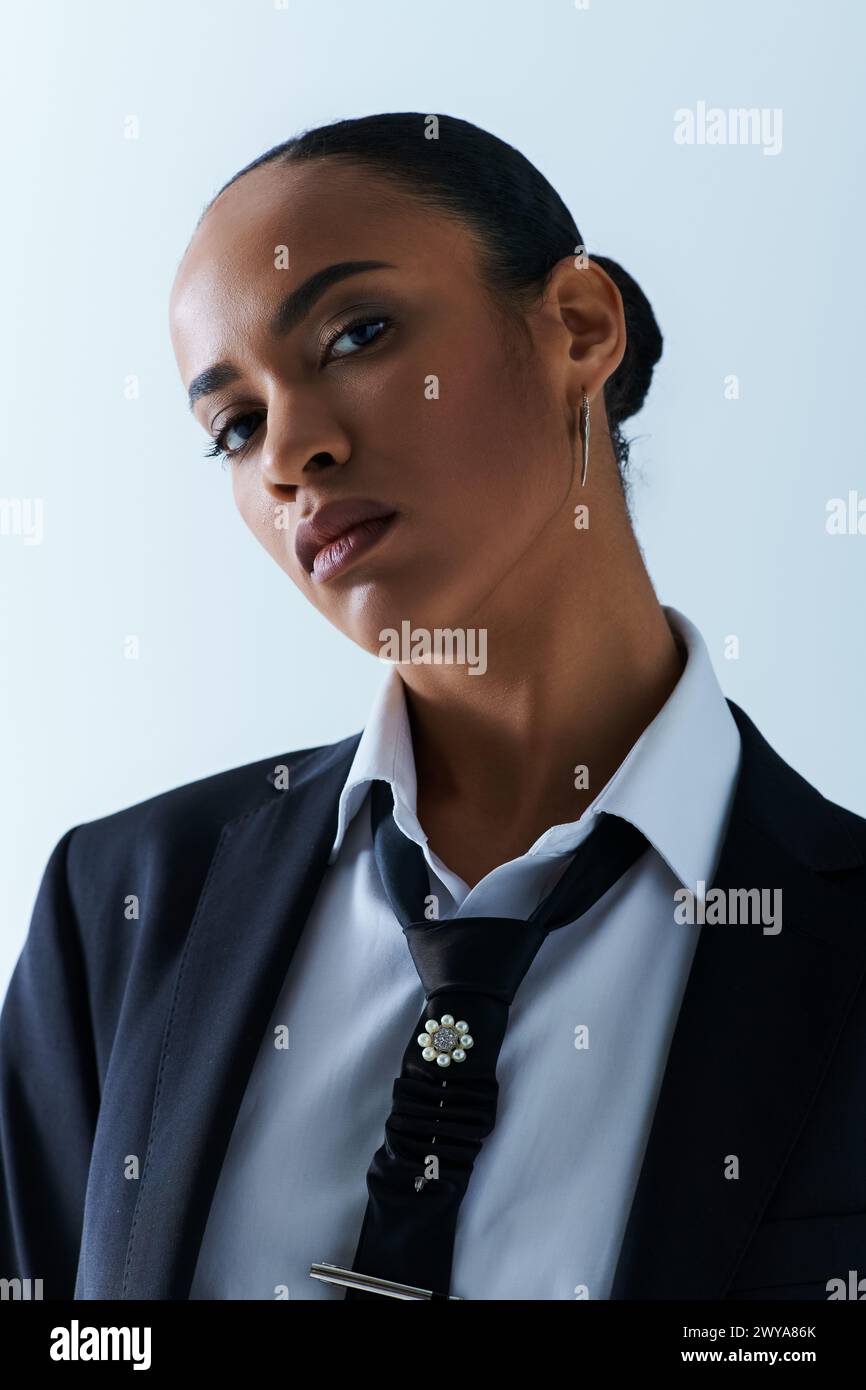 Una giovane donna afroamericana con cravatta nera e camicia bianca trasuda raffinatezza e stile Foto Stock
