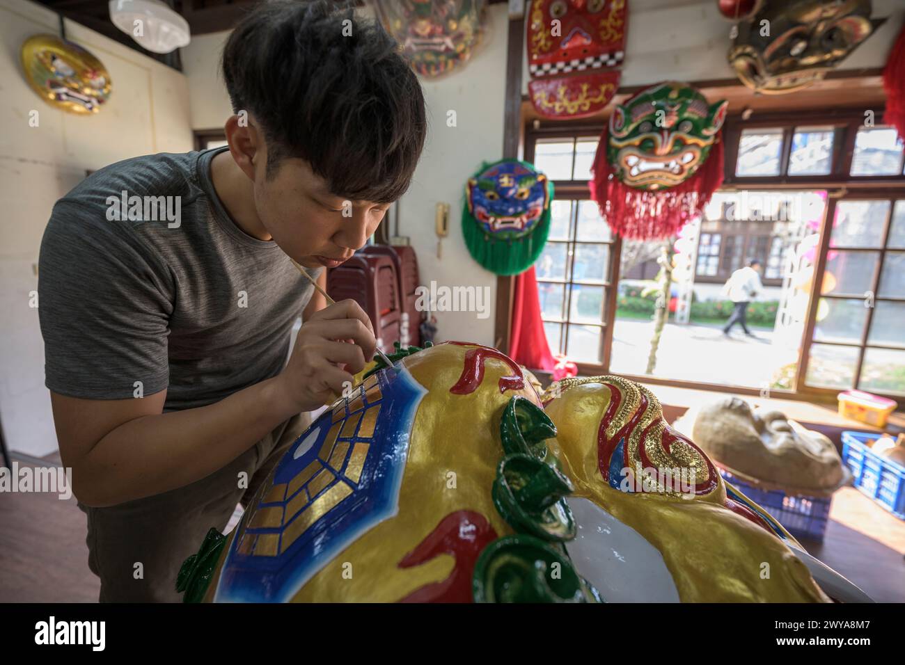 Primo piano di un dipinto artigianale disegni elaborati su una brillante scultura di drago dorato Foto Stock