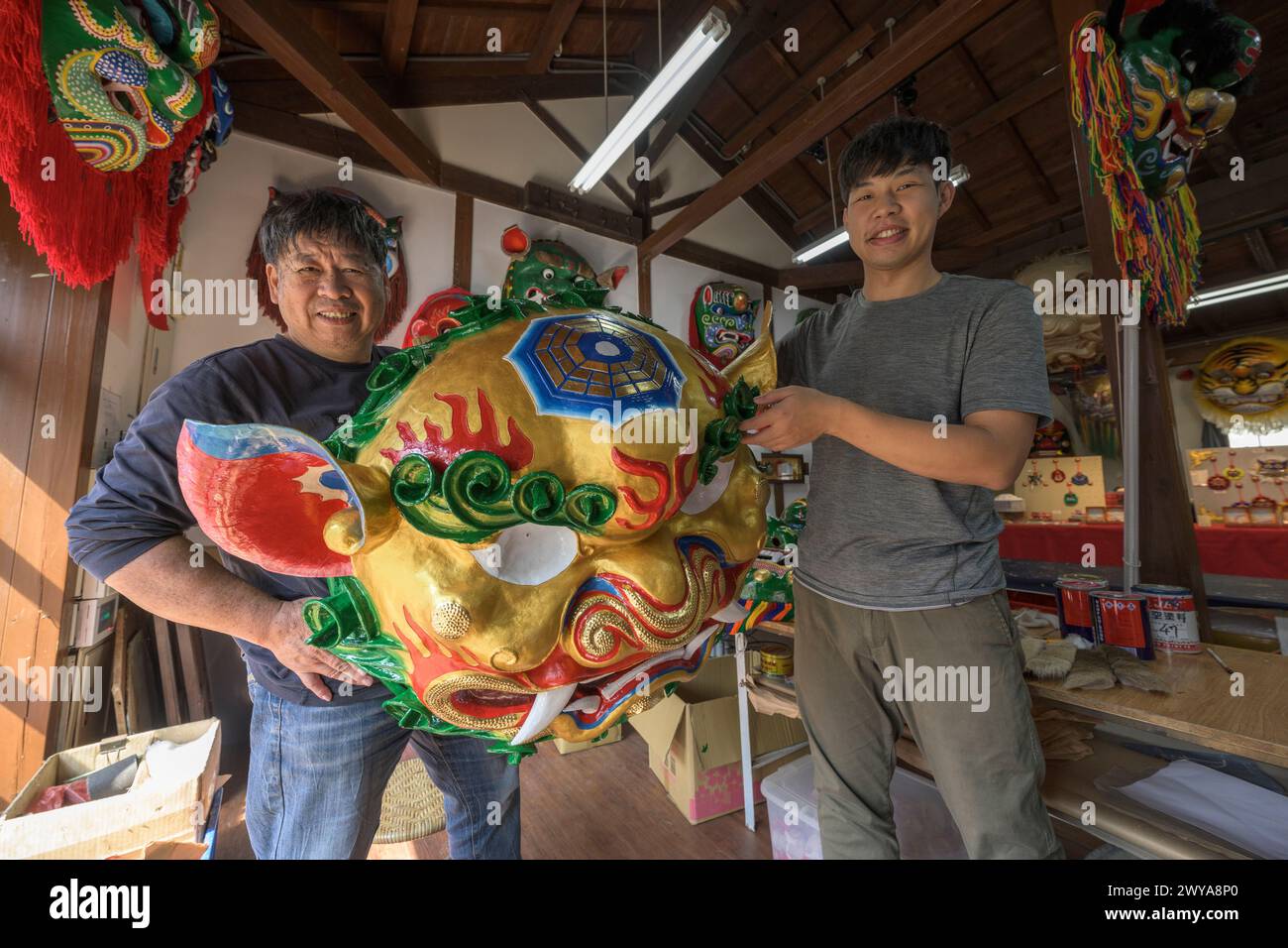 Artigiani che mostrano le maschere cerimoniali che realizzano in uno studio di artigianato tradizionale a Lukang Foto Stock