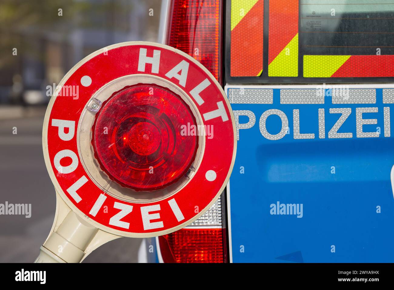 Controllo di polizia (Germania): Primo piano di una cazzuola di polizia con l'iscrizione STOP POLIZEI (Stop Police) di fronte a un veicolo di polizia (composizione) Foto Stock Controllo di polizia (Germania): Primo piano di una cazzuola di polizia con l'iscrizione STOP POLIZEI (Stop Police) di fronte a un veicolo di polizia (composizione) Foto Stock
