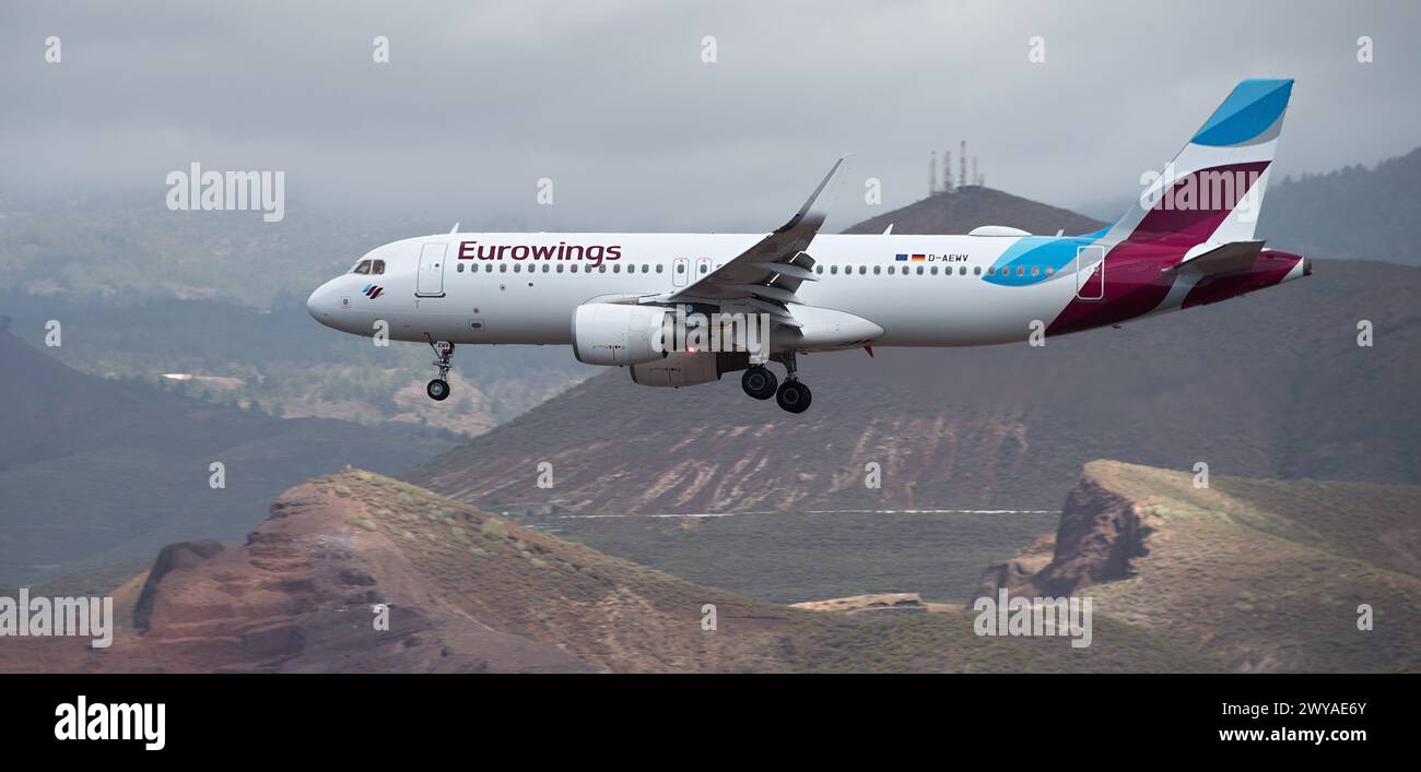 Tenerife, Spagna 31 marzo 2024. Airbus A320-214 Eurowings Airlines vola nel cielo blu con le nuvole. Atterraggio all'aeroporto di Tenerife. Montagne nel Foto Stock Tenerife, Spagna 31 marzo 2024. Airbus A320-214 Eurowings Airlines vola nel cielo blu con le nuvole. Atterraggio all'aeroporto di Tenerife. Montagne nel Foto Stock