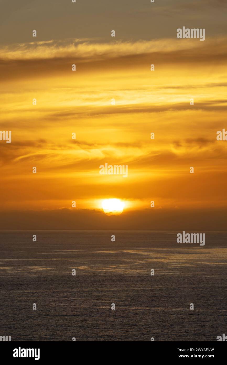 Cielo arancione con nuvole sull'oceano al tramonto sull'isola di Madeira, Portogallo Foto Stock