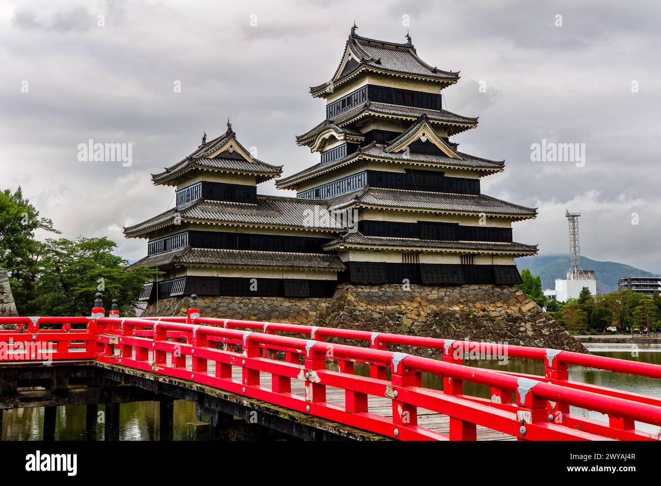 Ponte rosso di fronte a un antico castello giapponese (Matsumoto, Nagano) Foto Stock