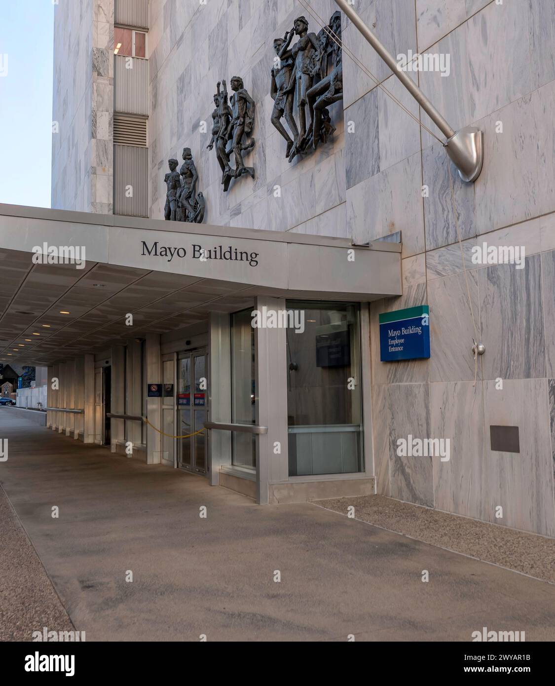 ROCHESTER, Minnesota – 14 dicembre 2023: Ingresso a Mayo Building con cartellonistica sul baldacchino sul marciapiede e sculture sulla facciata esterna sopra. Foto Stock
