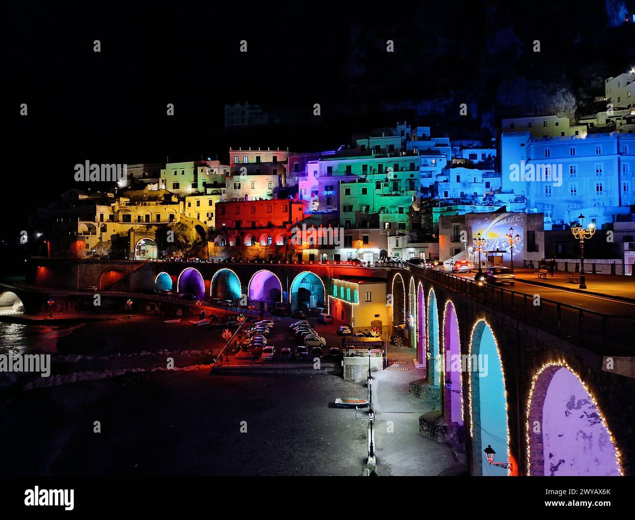 Vista notturna di Atrani e della sua spiaggia illuminata dalle luci natalizie Foto Stock