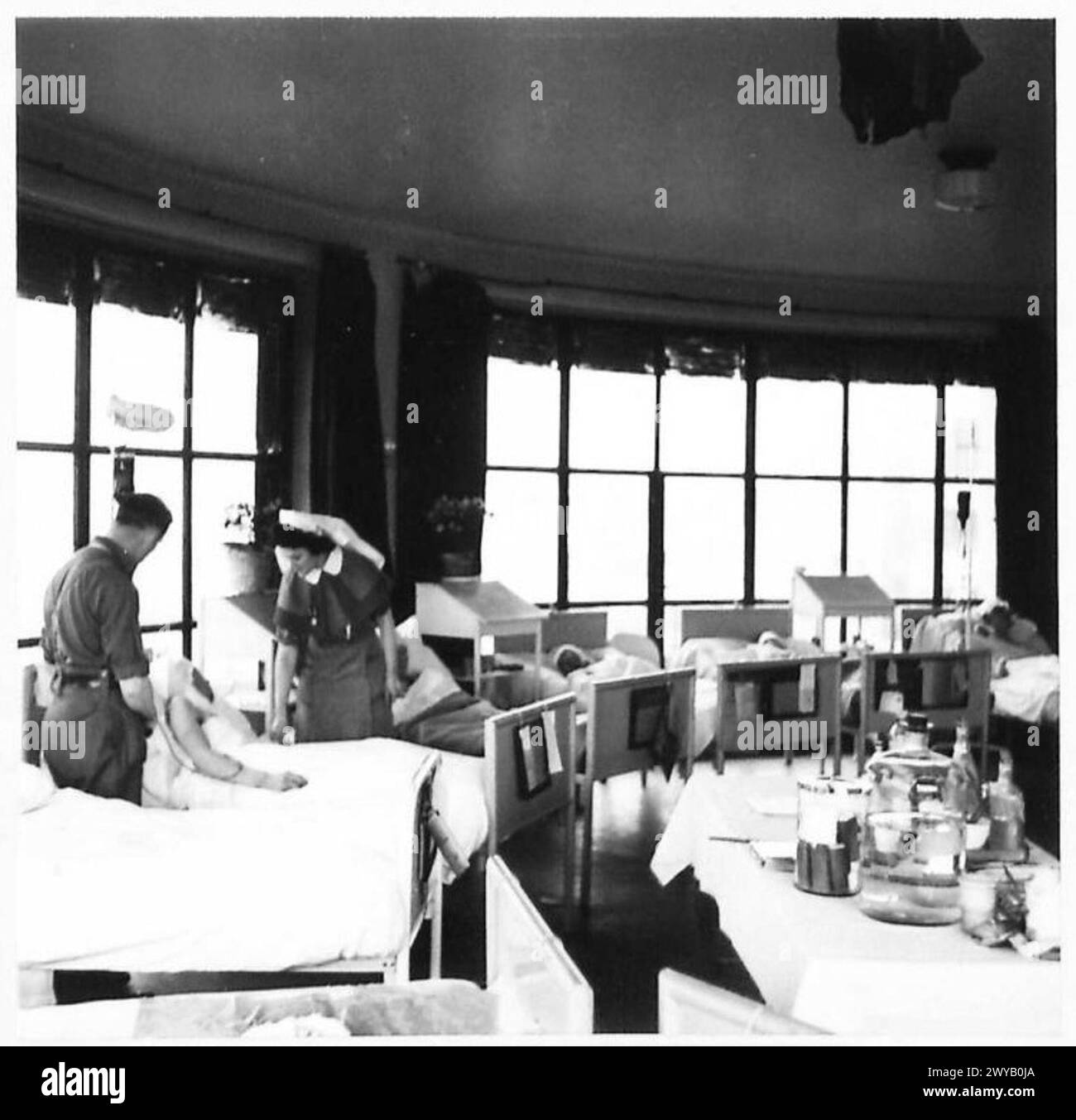 Il salone solare del British Military Hospital di Bruxelles è semicircolare per fornire ai pazienti la luce solare durante tutto il giorno. Suor E. Williams di Londra amministra trasfusioni di sangue ai pazienti. Foto Stock
