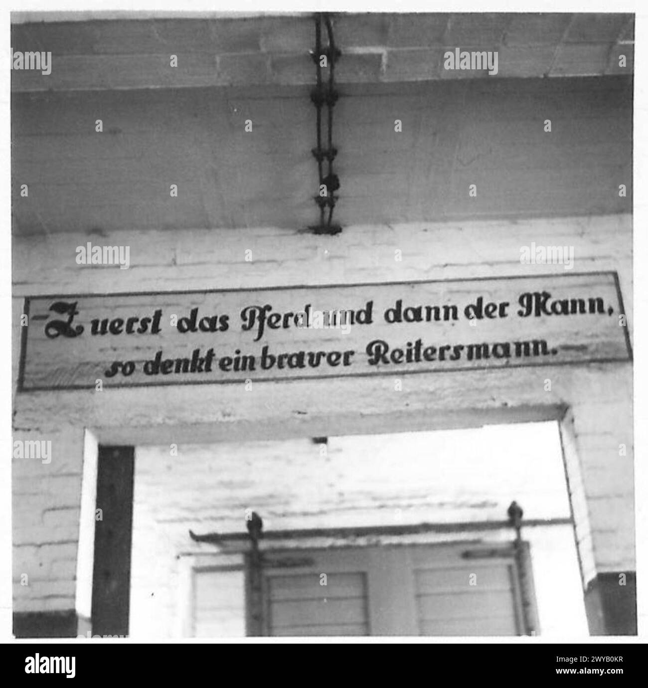 Le truppe in avanzata raggiungono celle, notando un avviso tedesco sopra la porta di un'ex camera di tortura. Foto Stock