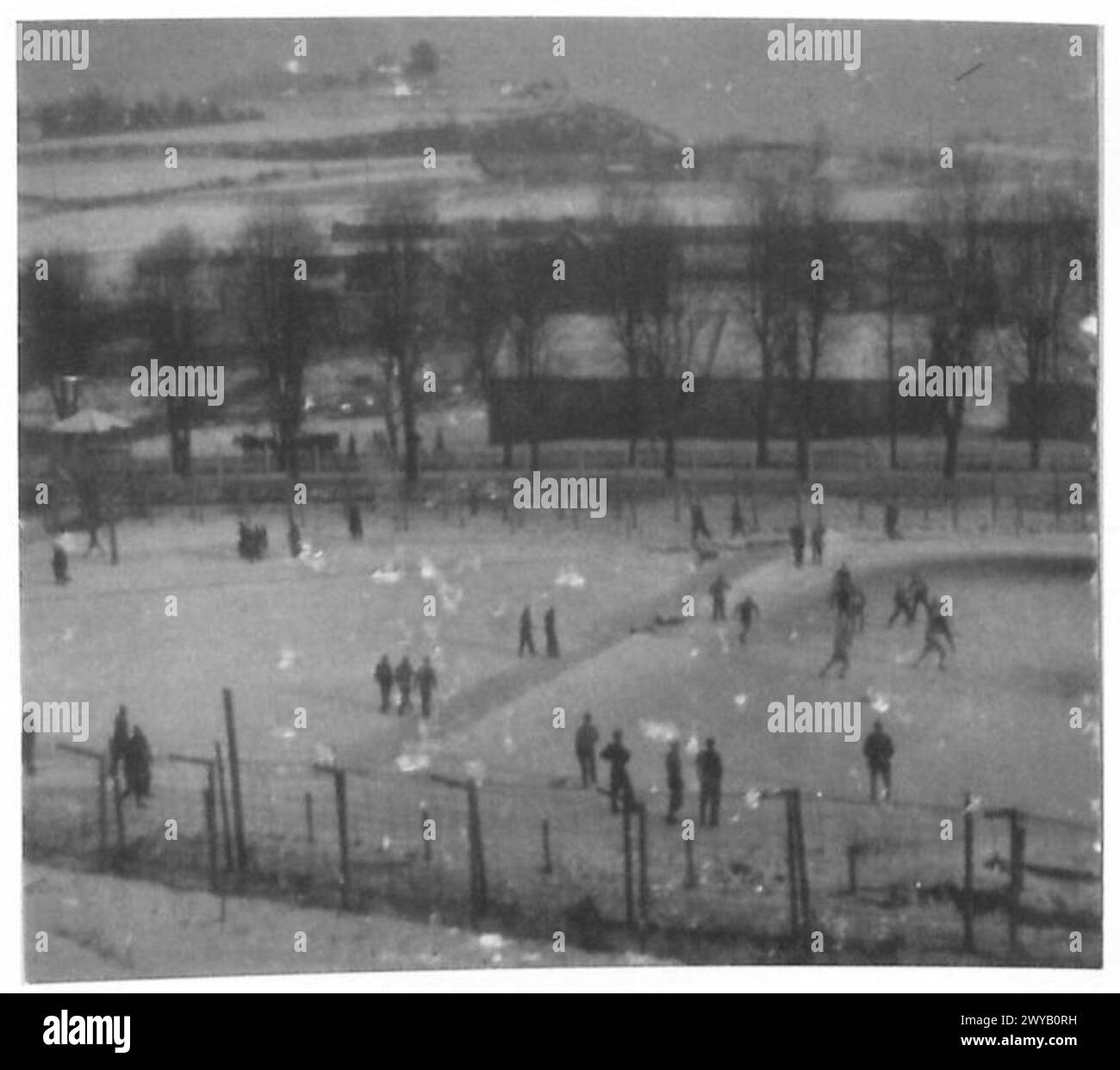 I prigionieri di guerra britannici all'Oflag VIII F in Germania sono visti giocare a calcio su terreni innevati nel dicembre 1943, con la campagna circostante visibile. Foto Stock