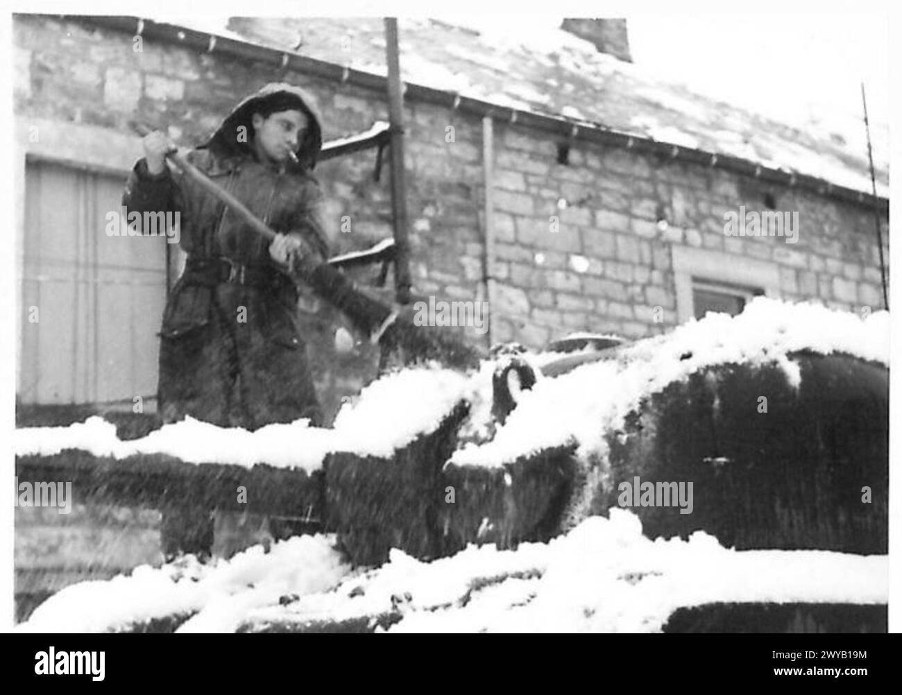 Il Trooper Ronald Selwyn dell'esercito britannico sgombra la neve dal portello del sedile del conducente durante le operazioni invernali. Foto Stock