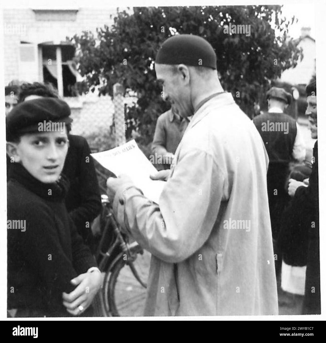 Un civile legge il giornale di liberazione francese "la Voix Des Allies" durante le operazioni dell'esercito britannico nelle aree liberate. Foto Stock