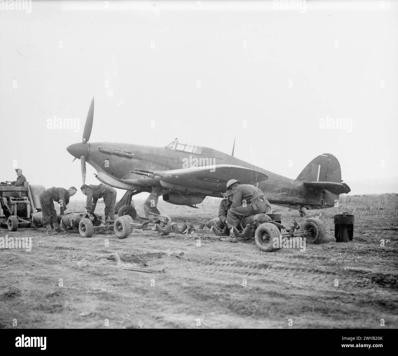 OPERAZIONI DELLA ROYAL AIR FORCE IN MEDIO ORIENTE E NORD AFRICA, 1939-1943. - Gli armatori del No. 241 Squadron RAF stanno per caricare due bombe GP da 500 libbre sull'Hawker Hurricane TAC R Mark IIC, HV638, a Souk el Arba ('Sloane Square'), Tunisia. , Royal Air Force, gruppo, 241 Foto Stock