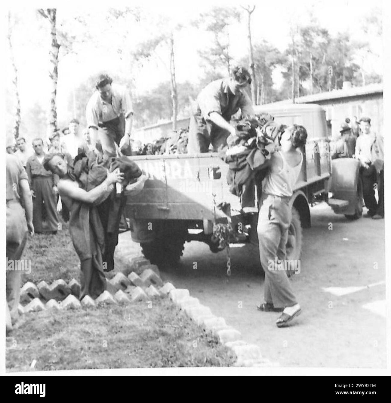 L'abbigliamento fornito dai tedeschi viene scaricato da un camion U.N.R.R.A. per gli sfollati italiani, British Army, 21st Army Group. Foto Stock