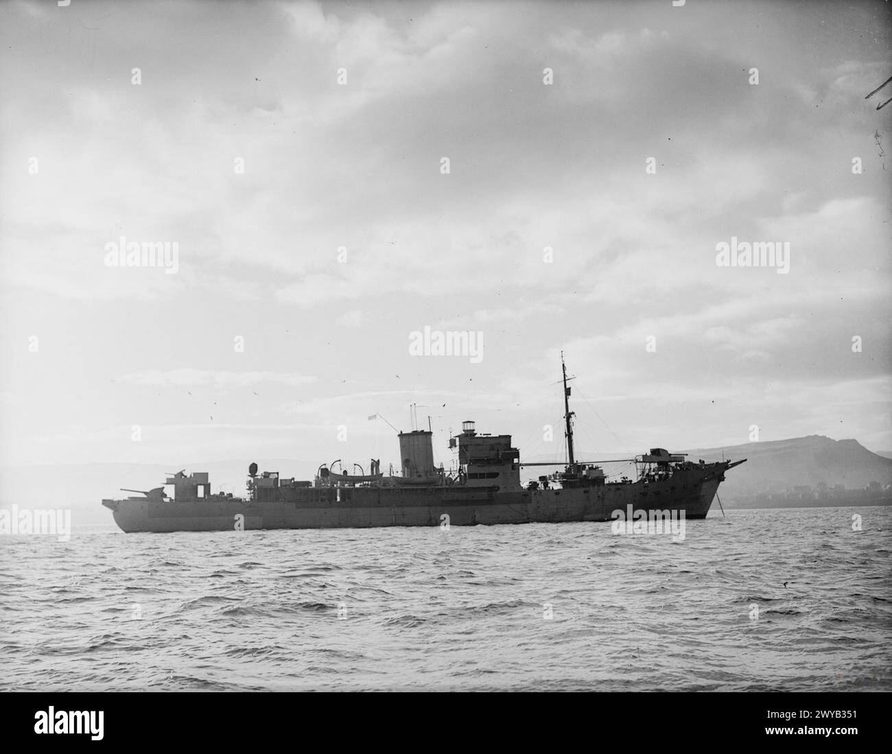 LA ROYAL NAVY DURANTE LA SECONDA GUERRA MONDIALE - HMS LARGS, nave britannica d'imbarco sull'oceano, 7 gennaio 1941, Greenock. HMS LARGS, ex CHARLES PLUMIER, AMC francese, catturata dal cacciatorpediniere HMS FAULKNOR, 22 novembre 1940 al largo di Gibilterra. Vista della HMS LARGS presa in mare dalla HMS FAULKNOR che mostra un profilo laterale di dritta completo della nave al suo ormeggio. Le colline di Greenock possono essere viste sullo sfondo, oltre il lato porto della nave. , HMS Largs (Ex-Charles Plumier, ribattezzato 1941) Foto Stock