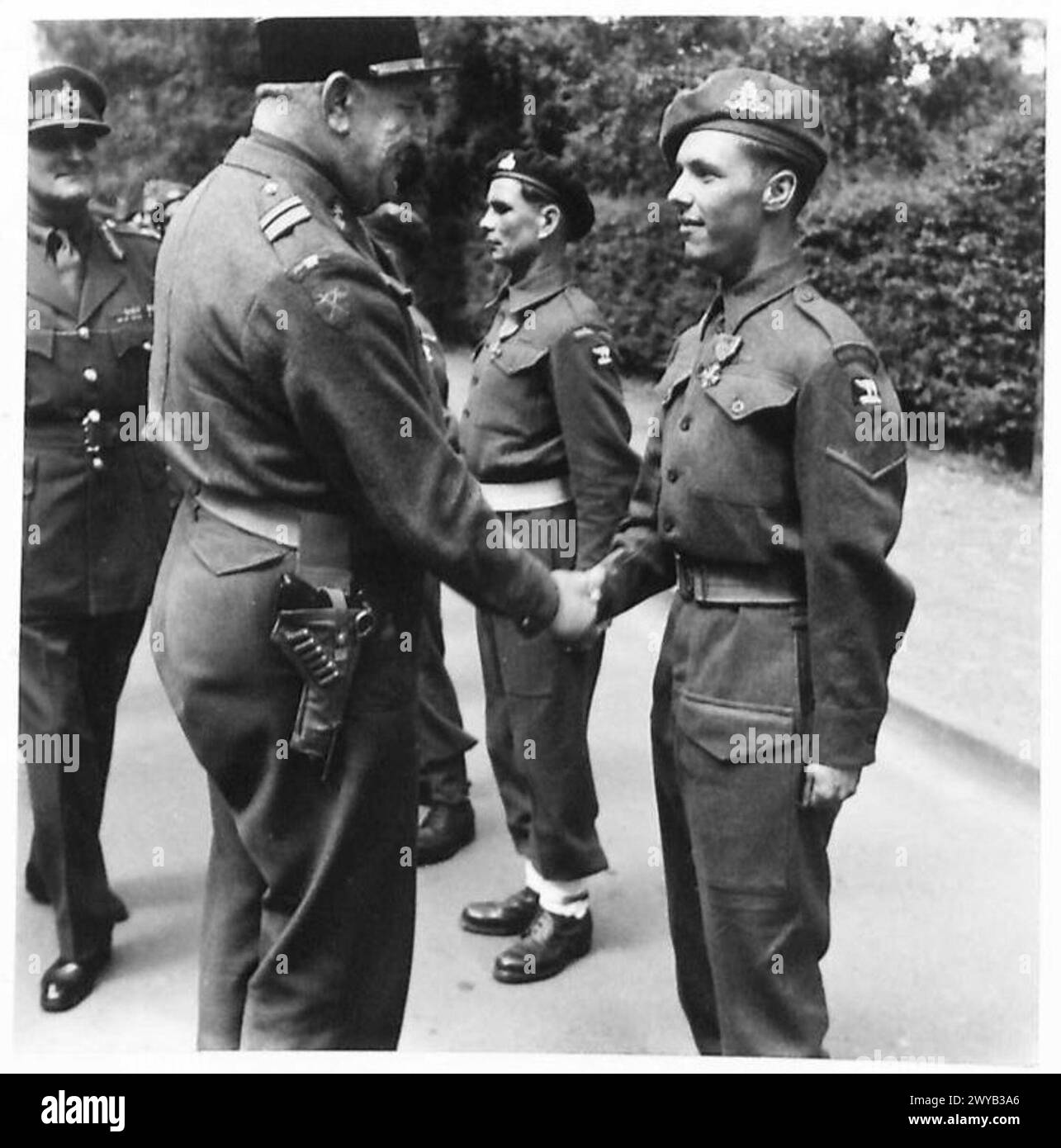 L/Bombardier W. King della Royal Artillery riceve la Croix de Guerre durante una cerimonia di investitura per ufficiali e uomini della 49a Divisione. Foto Stock