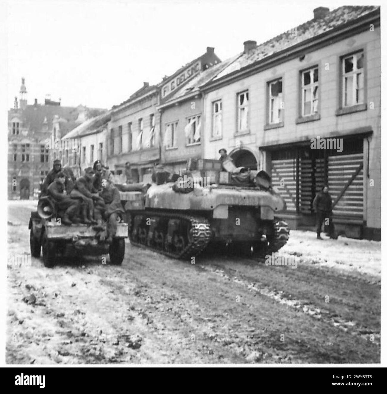 Gli uomini del 9th Battalion Durham Light Infantry avanzano verso Echt mentre i prigionieri catturati guardano nella parte settentrionale della città. Il British Army, 21st Army Group, documentò l'operazione. Foto Stock