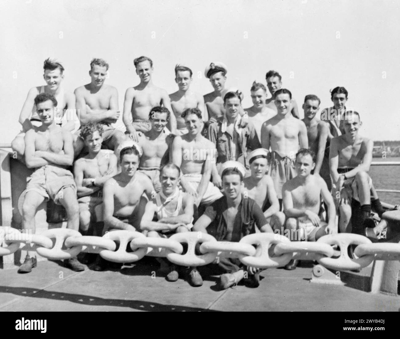 I membri dell'equipaggio di Glaswegian sono raffigurati a bordo della portaerei di scorta HMS Empress il 16 agosto 1945, parte della flotta britannica delle Indie Orientali, mostrando ufficiali e valutazioni nelle loro posizioni assegnate. Foto Stock