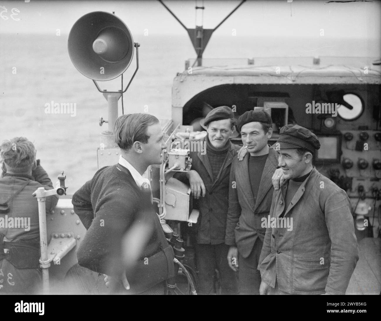 Il primo tenente della HMS Bleasdale parla con i pescatori francesi mentre radunano le navi in una zona vietata, dal 10 al 16 settembre 1942. Foto Stock
