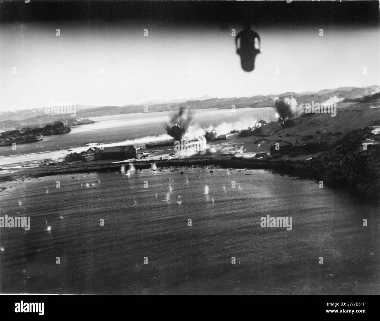 ROYAL AIR FORCE BOMBER COMMAND, 1939-1941. - Bombe scoppiarono sul campo di aviazione di Herdla, Norvegia, durante un attacco di basso livello da parte di 13 Bristol Blenheim Mark IV del No. 114 Squadron RAF, a sostegno del raid delle Combined Operations su Vaagso. La fotografia è stata scattata da uno degli aerei attaccanti usando una telecamera rivolta indietro. Bombe che esplosero sull'aeroporto tedesco di Herdla in Norvegia, durante un attacco di basso livello da parte dei Bristol Blenheim del No. 114 Squadron, parte del raid Combined Operations su Vaagso, il 27 dicembre 1941. , British Army, Royal Flying Corps, Training Sqdn, 6 Foto Stock