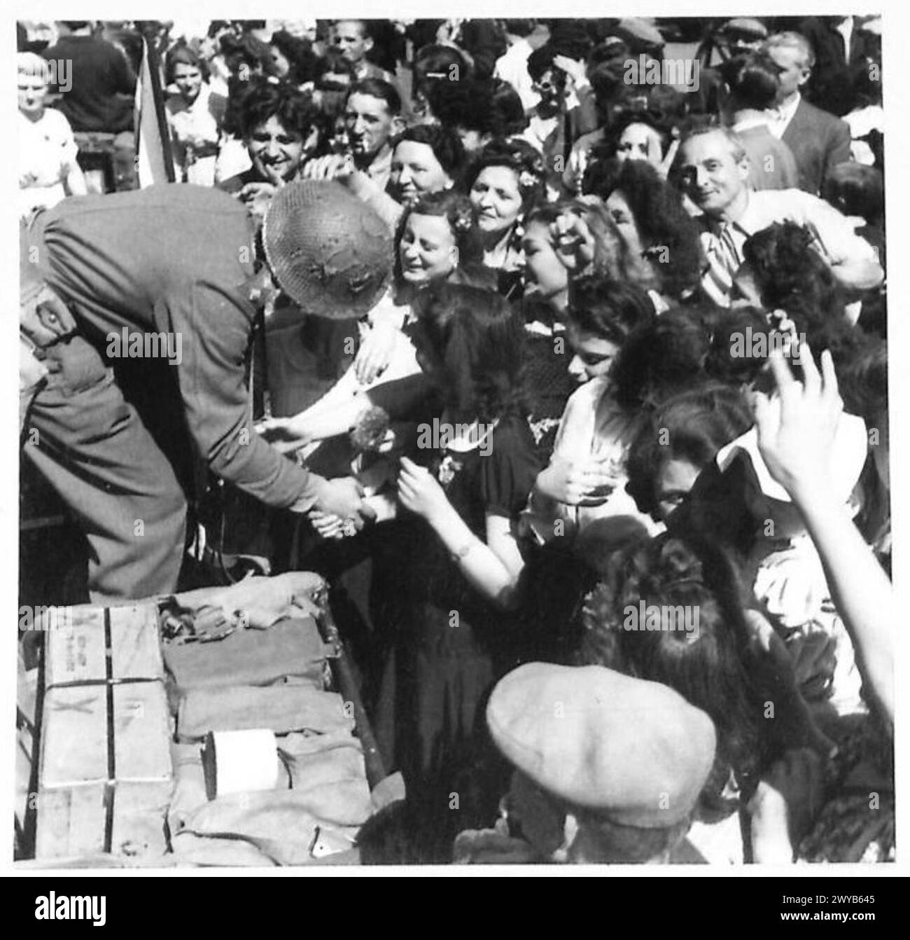 I civili a Parigi si allineano per le strade per salutare le truppe inglesi, americane, canadesi e francesi che entrano nella città liberata dopo le operazioni. Foto Stock