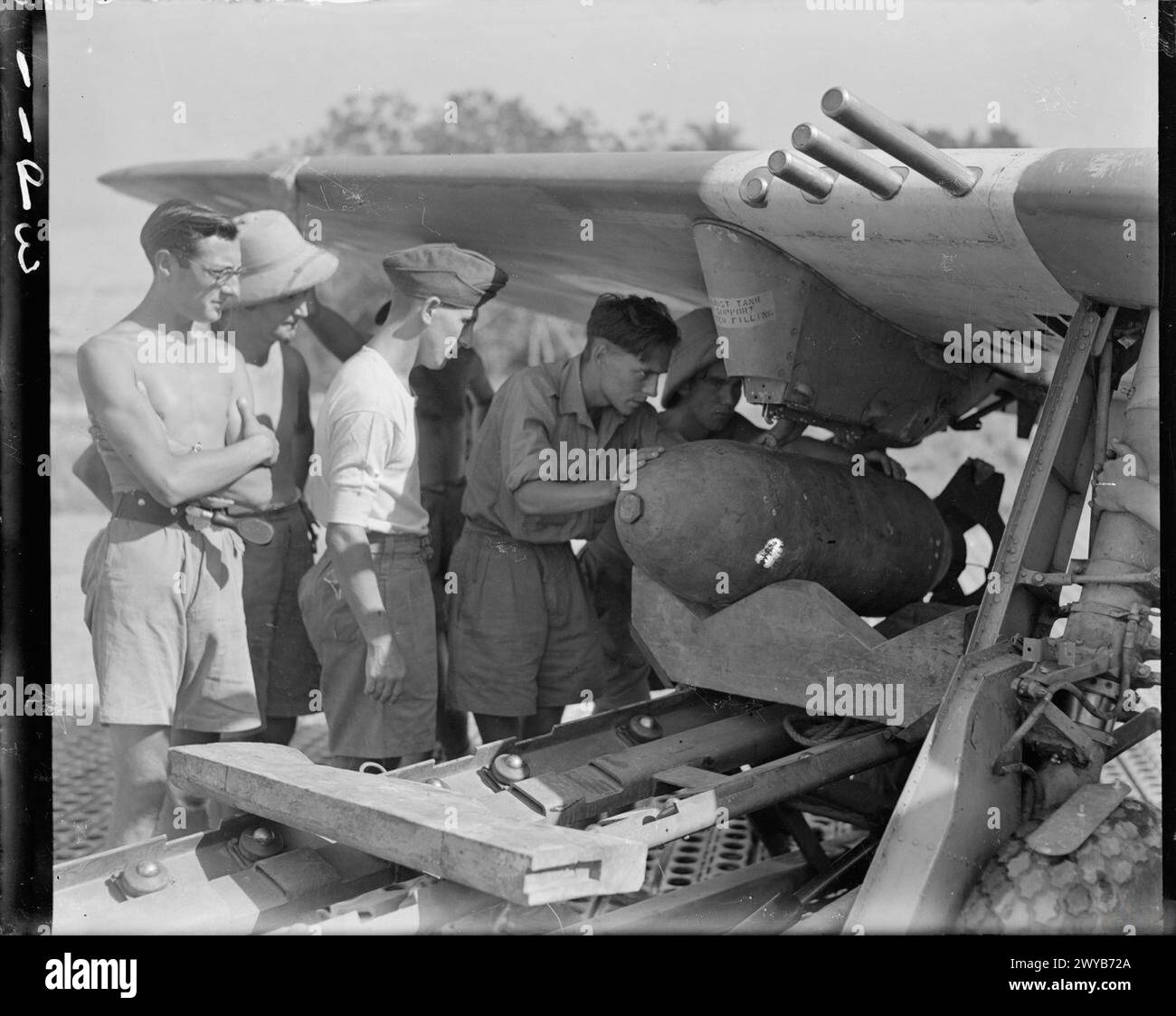 Gli Armourers si preparano ad attaccare una bomba GP da 500 libbre al pilone dell'ala di un Republic Thunderbolt Mark II del No. 30 Squadron RAF a Jumchar, India. Foto Stock