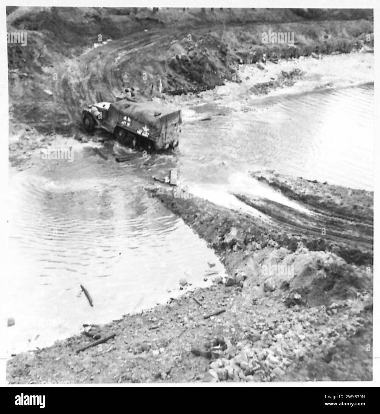 Un'ambulanza britannica attraversa il canale Dortmund-EMS attraverso un guado costruito da bulldozer, mentre corazzature e trasporti avanzano, British Army, 21st Army Group. Foto Stock