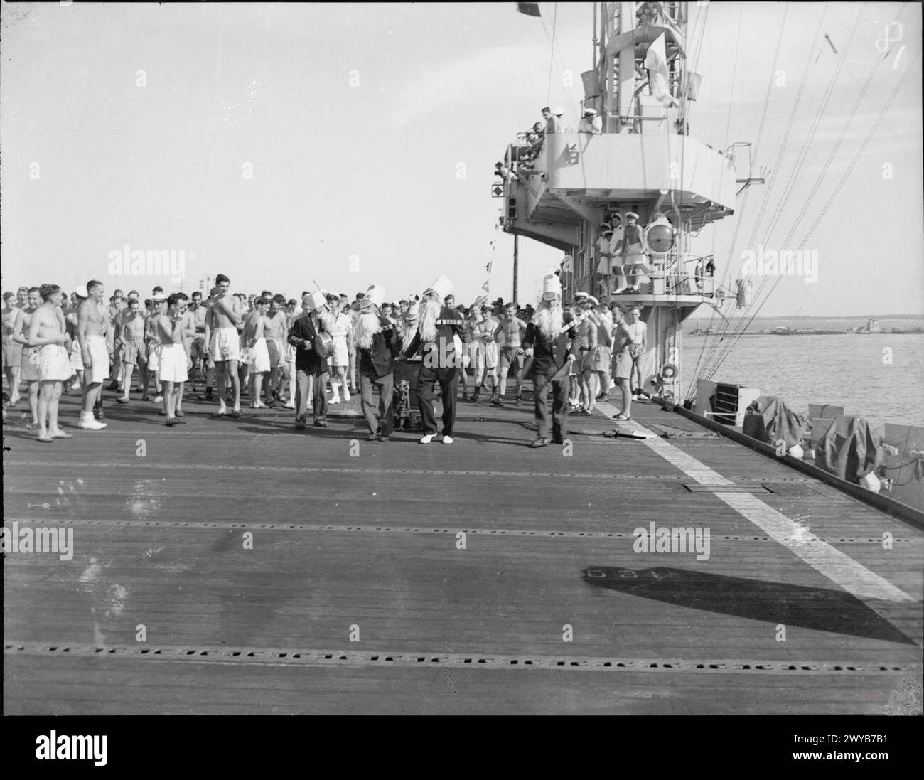 I membri di "The Ancient Mariners" si esibiscono durante una sfilata di abiti eleganti sul ponte di volo della portaerei di scorta della Royal Navy HMS Shah nelle acque orientali, 1943. Foto Stock