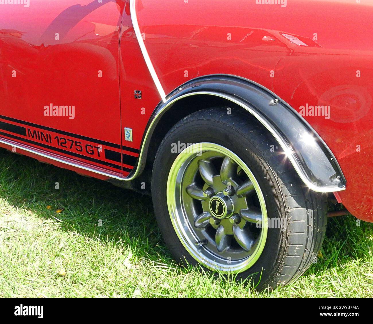 Vista laterale di una classica Mini 1275 GT in rosso che mostra la ruota anteriore e il rivestimento laterale Foto Stock