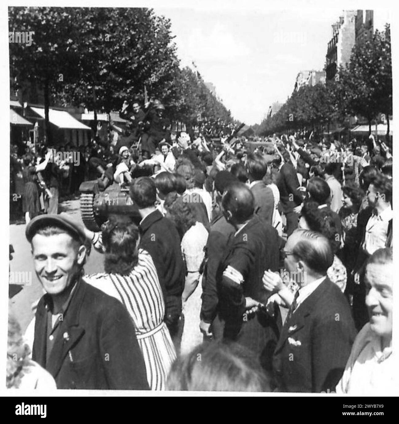 La folla di Parigi percorre le strade per salutare le truppe britanniche, americane, canadesi e francesi che entrano nella città liberata, mostrando scene di giubilo. Foto Stock
