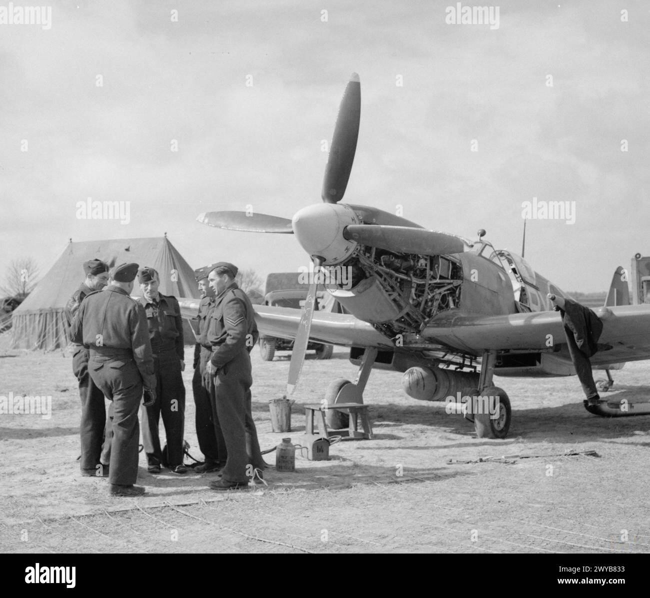 ROYAL AIR FORCE 1939-1945: FIGHTER COMMAND - Uno Spitfire LF IX del No 313 Squadron sottoposto ad un cambio olio presso Appledram ALG (Advanced landing ground), vicino a Tangmere, 19 aprile 1944. Molti squadroni di combattimento operavano da bande temporanee nel sud dell'Inghilterra, i loro piloti e i loro addetti al servizio si abituavano a "russare" allo scoperto come preparazione per il futuro dispiegamento nel continente. I tre squadroni di Spitfire con equipaggio ceco che pilotavano operazioni di scorta da Appledram in quel momento (nn. 310, 312 e 313) facevano parte del No 84 Group, 2nd Tactical Air Force. Il personale include Frantisek F. Foto Stock