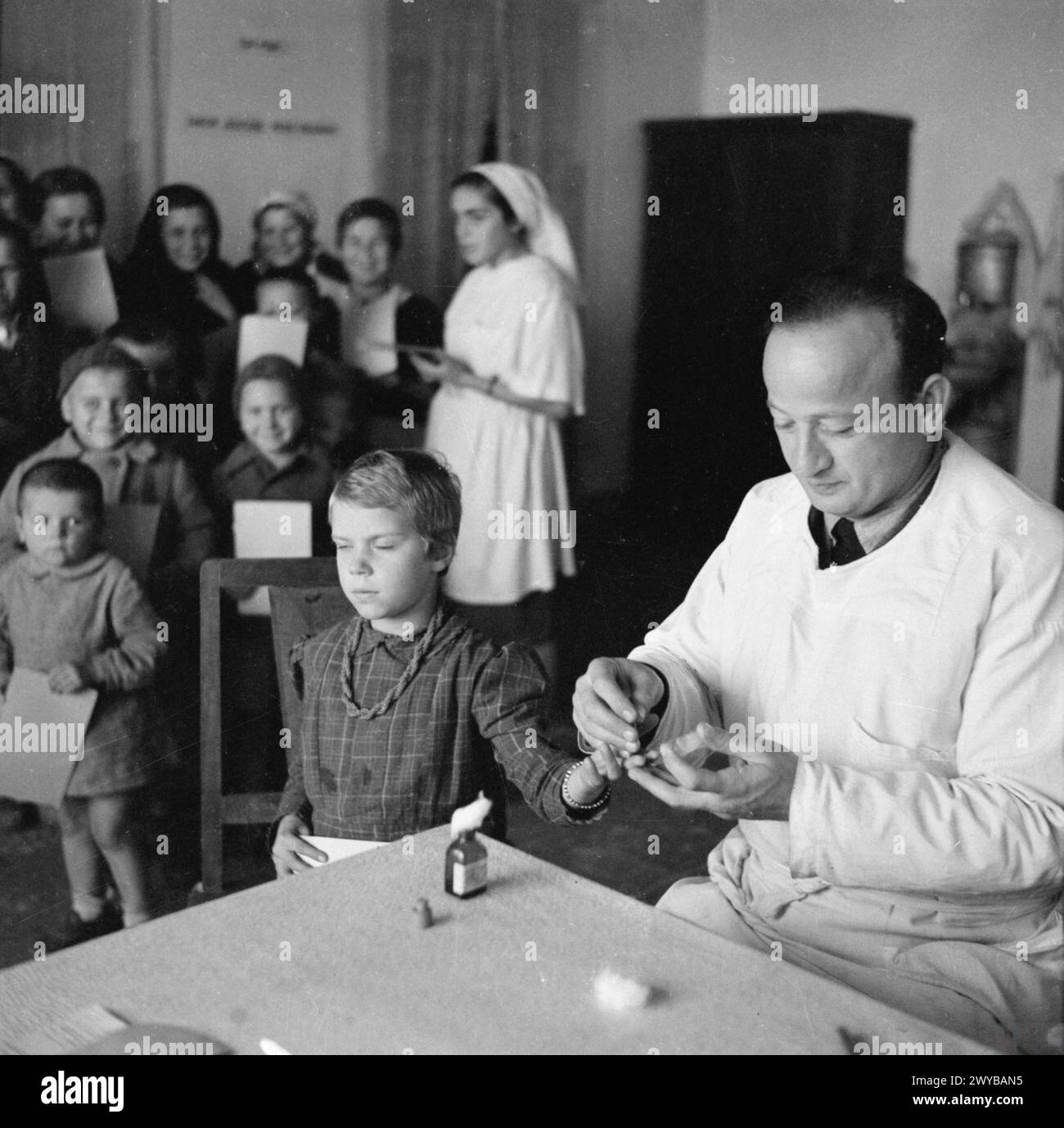 RIFUGIATI POLACCHI IN PERSIA, 1942-1945 - Un medico polacco fa un esame del sangue da una bambina in un centro medico di Teheran. Ci sono molti rifugiati polacchi a Teheran, in Persia. Queste immagini mostrano alcuni dei bambini sul periodo natalizio. Sono orfani deportati dai sovietici in Siberia nel 1939 e evacuati dall'Unione Sovietica in Persia e Palestina con il corpo principale del futuro 2° corpo polacco. , Foto Stock