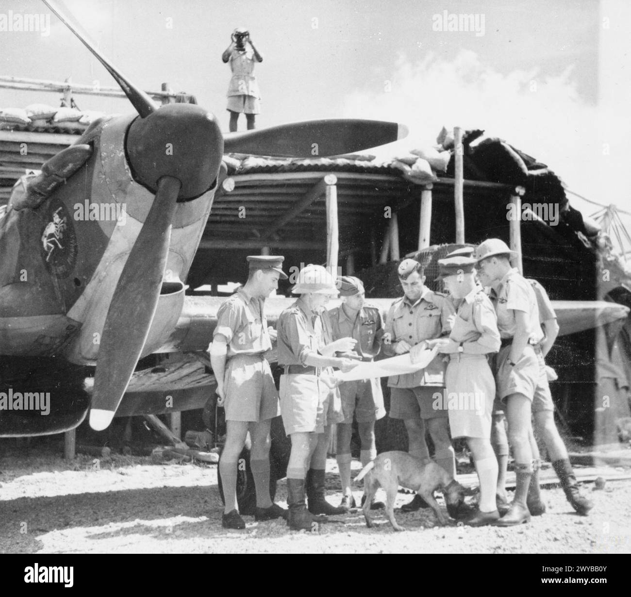 ROYAL AIR FORCE: COMANDO DELL'AFRICA ORIENTALE, 1940-1945. - Il maggiore J D Pretorius, comandante del No. 3 Squadron SAAF, informa i suoi piloti di fronte a un Hawker Hurricane Mark i ad Addis Abeba, durante le operazioni di mopping in Abissinia. Nota 3 il distintivo dell'unità dello Squadrone sul lato destro del naso dell'uragano. , South African Air Force, Sqdn, 3 Foto Stock