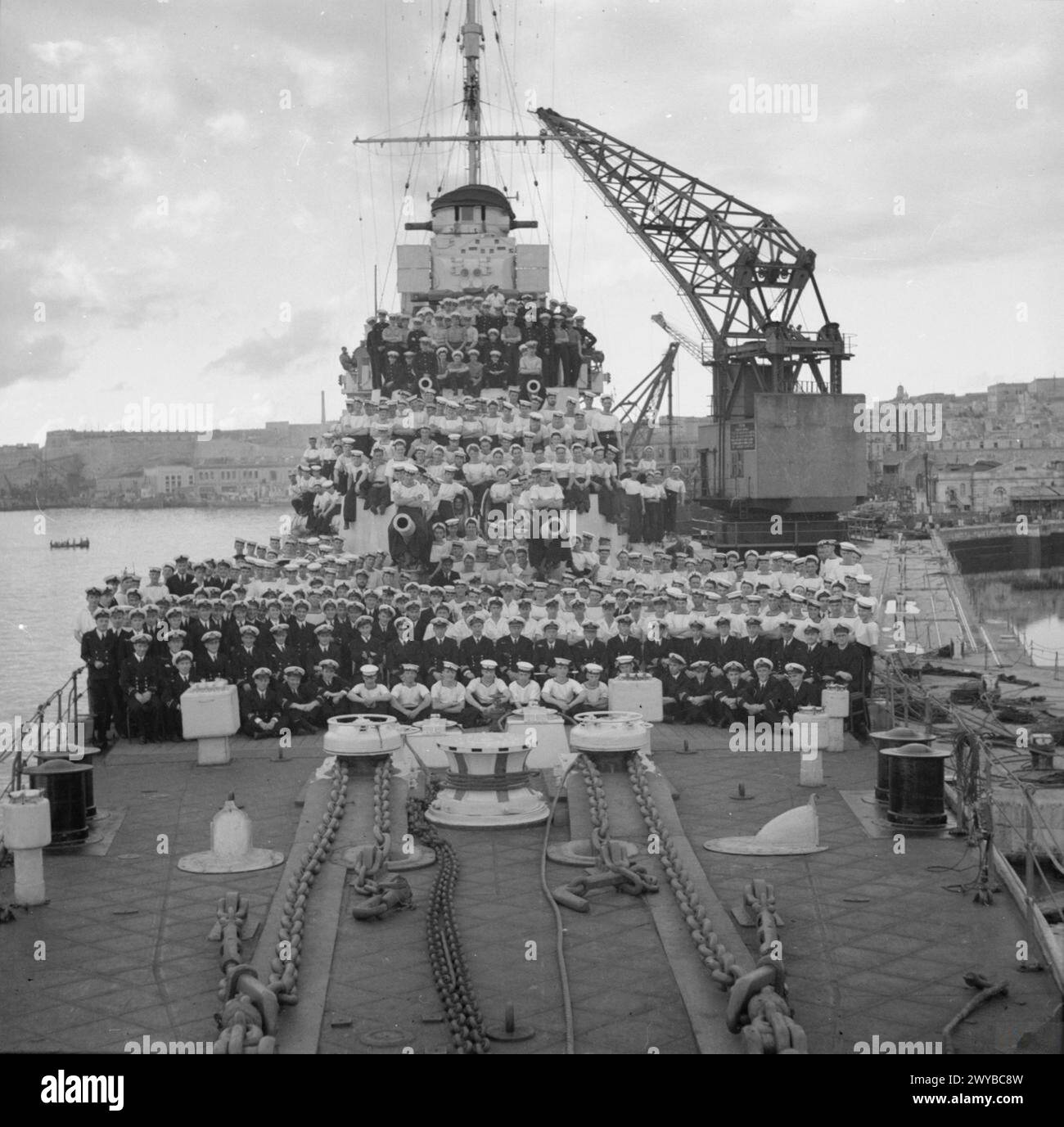 AGNEW DELL'AURORA CON LA COMPAGNIA DELLA SUA NAVE. NOVEMBRE 1941. LE UNITÀ NAVALI BRITANNICHE, DUE INCROCIATORI HMS AURORA E HMS PENELOPE E DUE CACCIATORPEDINIERE HMS LIVELY E HMS LANCE SOTTO IL COMANDO DEL CAPITANO W G AGNEW, CB, RN, ANNIENTARONO DUE CONVOGLI DI ASSE, 10 VASCELLI DI RIFORNIMENTO E DUE CACCIATORPEDINIERE ITALIANI NELLA NOTTE DELL'8/9 NOVEMBRE. PER QUESTA AZIONE GALANTE E DI SUCCESSO HM IL RE APPROVÒ L'ASSEGNAZIONE DEL "COMPAGNO DEL BAGNO" AL CAPITANO W G AGNEW. - Capitano W G Agnew, CB, RN (al centro) con i suoi ufficiali e la compagnia di navi a bordo della HMS AURORA. , Foto Stock