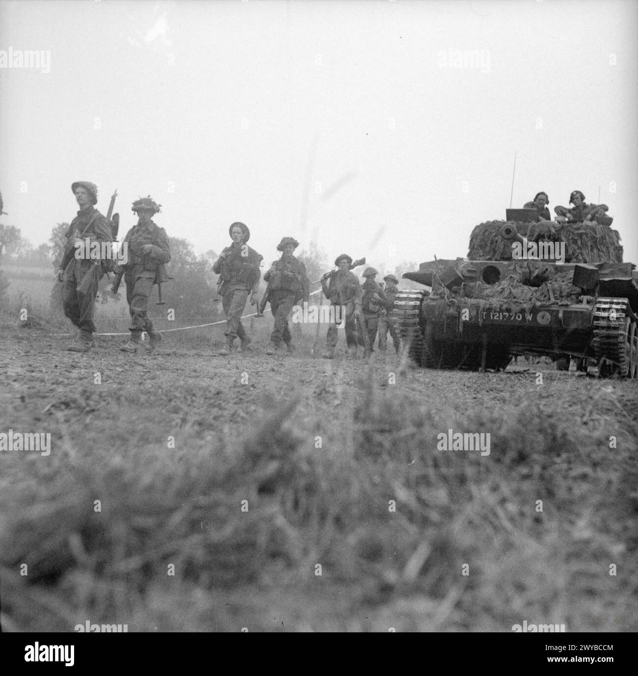 La fanteria e i carri armati avanzarono vicino a le Beny Bocage durante l'offensiva britannica a sud di Caumont. L'operazione mirava a catturare le posizioni chiave e stabilire una testa di ponte attraverso il fiume Souleuvre. Foto Stock