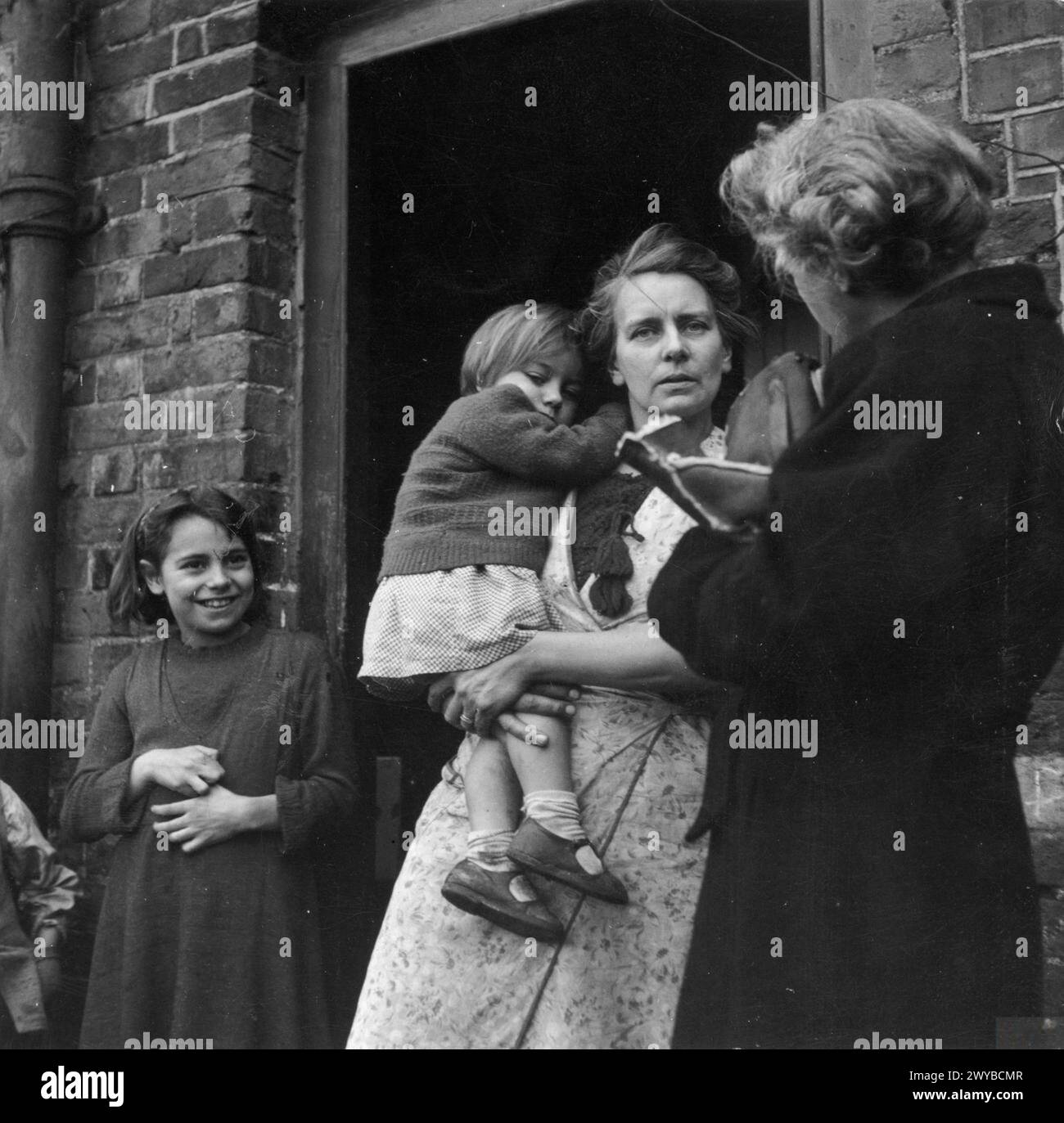 La signora R, Welfare Officer for High Wycombe Rural District Council, visita una famiglia nel loro nuovo cottage nel Buckinghamshire, Inghilterra, nel 1944 per assicurarsi che siano sistemati e abbiano i mobili necessari. Foto Stock