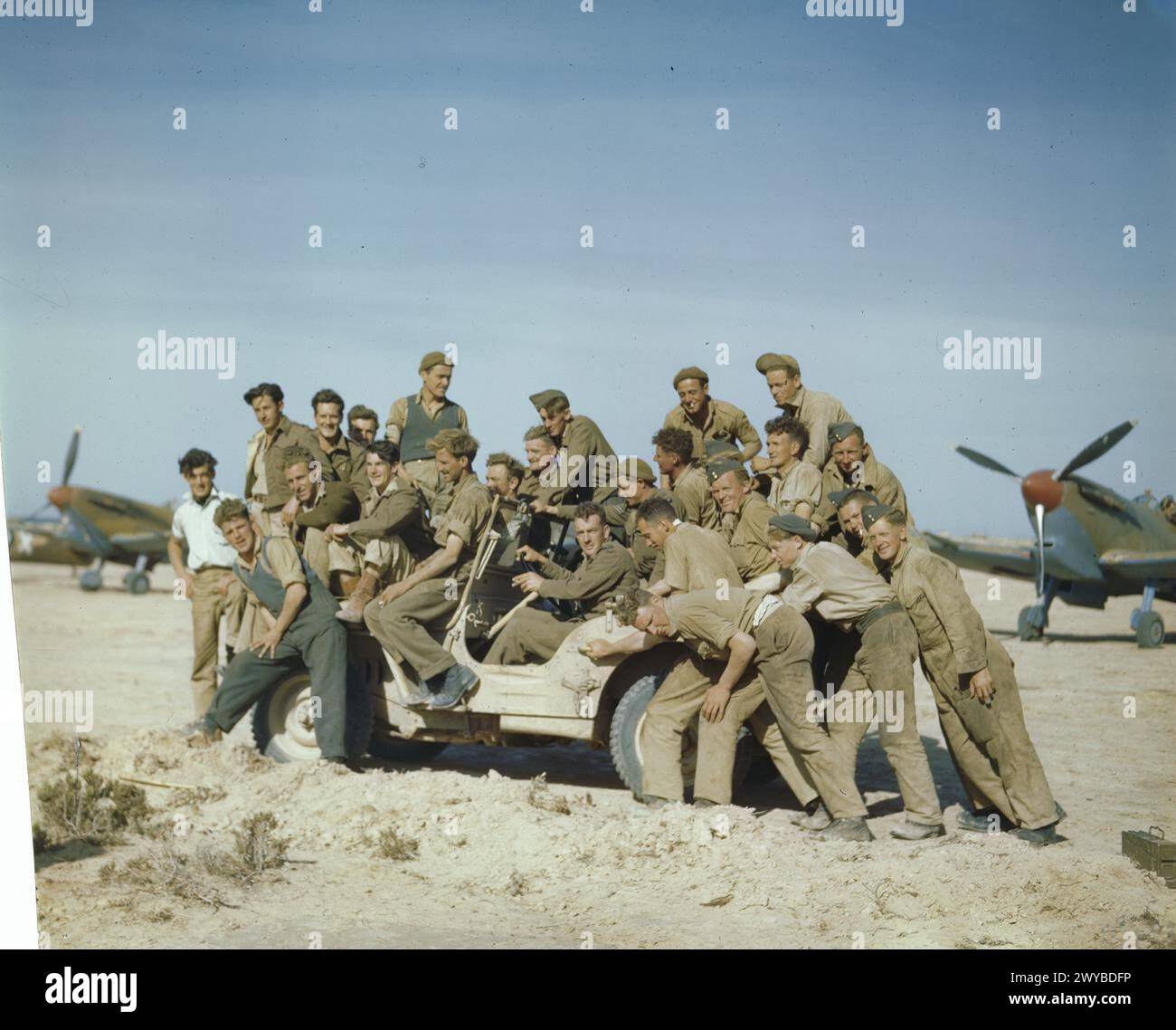 LA ROYAL CANADIAN AIR FORCE IN TUNISIA, APRILE 1943 - gli equipaggi di terra del No 417 Squadron, la Royal Canadian Air Force che viaggiano dentro e intorno a una jeep affollata a Goubrine, in Tunisia. Supermarine Spitfire Mark vs dello Squadron sono sullo sfondo. , Royal Canadian Air Force, 417 Squadron Foto Stock