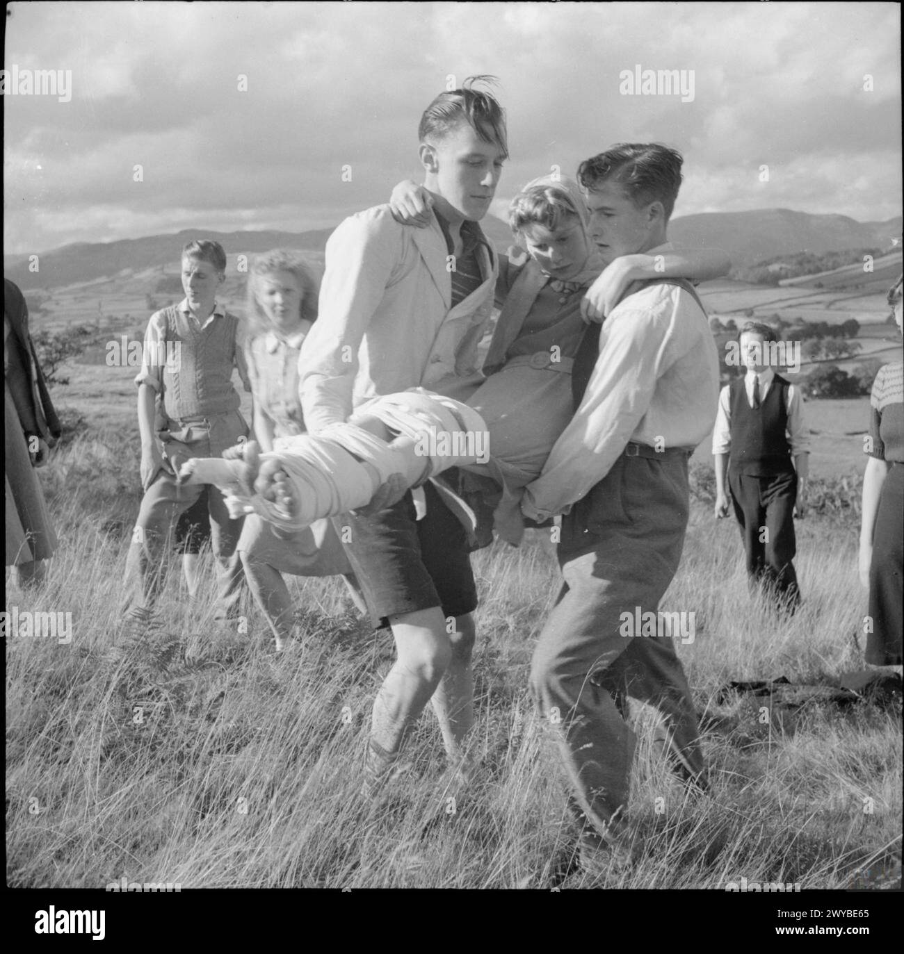 A luglio e agosto 1943, gli studenti della Co-operative Union Summer School della Craig School, Lake Windermere, hanno praticato il primo soccorso in un'escursione a piedi. Gli istruttori della St John's Ambulance Brigade, guidati dal signor F Kay, hanno supervisionato le attività, tra cui l'applicazione di stecche e bende. Foto Stock