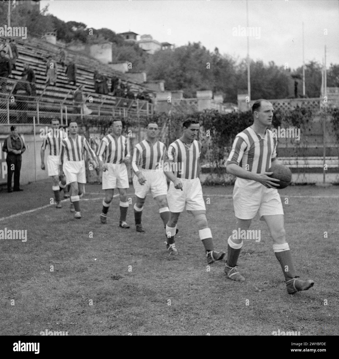 Le squadre di calcio dell'Esercito britannico e del 2° corpo polacco giocano a Roma il 14 novembre 1944 durante la campagna d'Italia, osservate da una grande folla nonostante i cambiamenti meteorologici. Foto Stock
