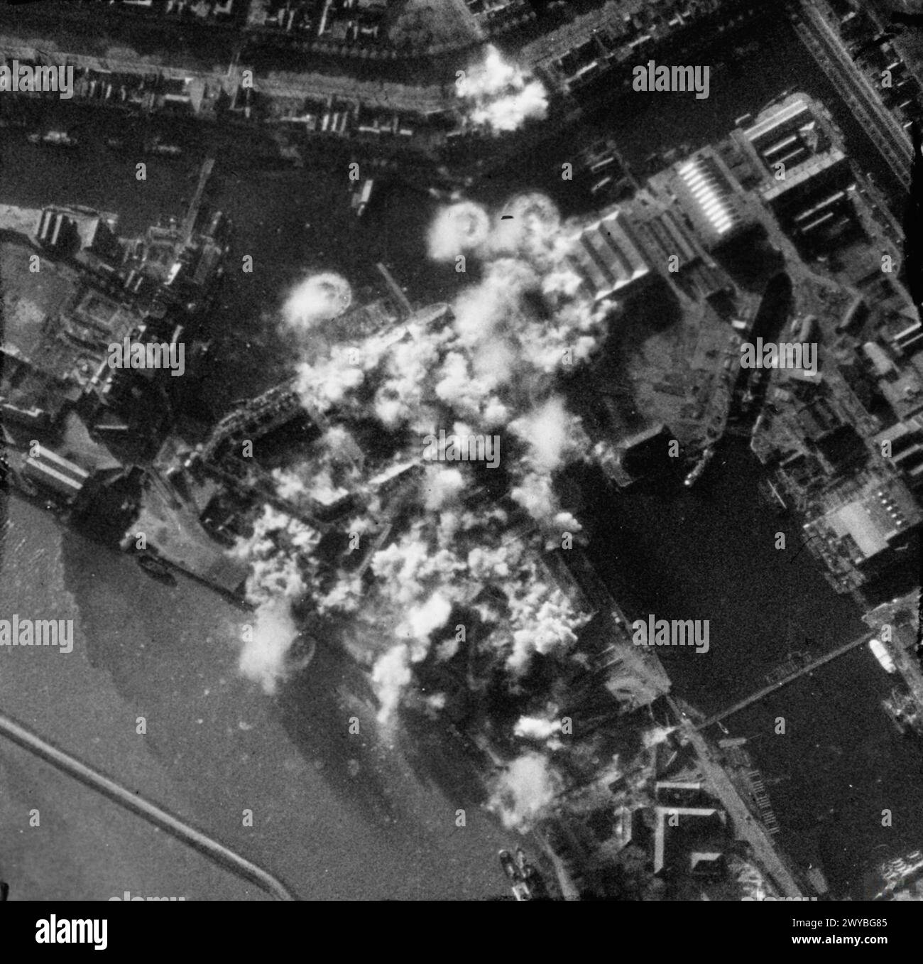 Fotografia aerea che mostra sei Lockheed Venturas del No. 21 Squadron RAF che attaccano le officine di siluri e le caserme navali a Den Helder, Paesi Bassi, con 36 bombe su 42 che esplodono con precisione, causando danni significativi durante un'operazione "Circus" diurna, 1942-1945. Foto Stock