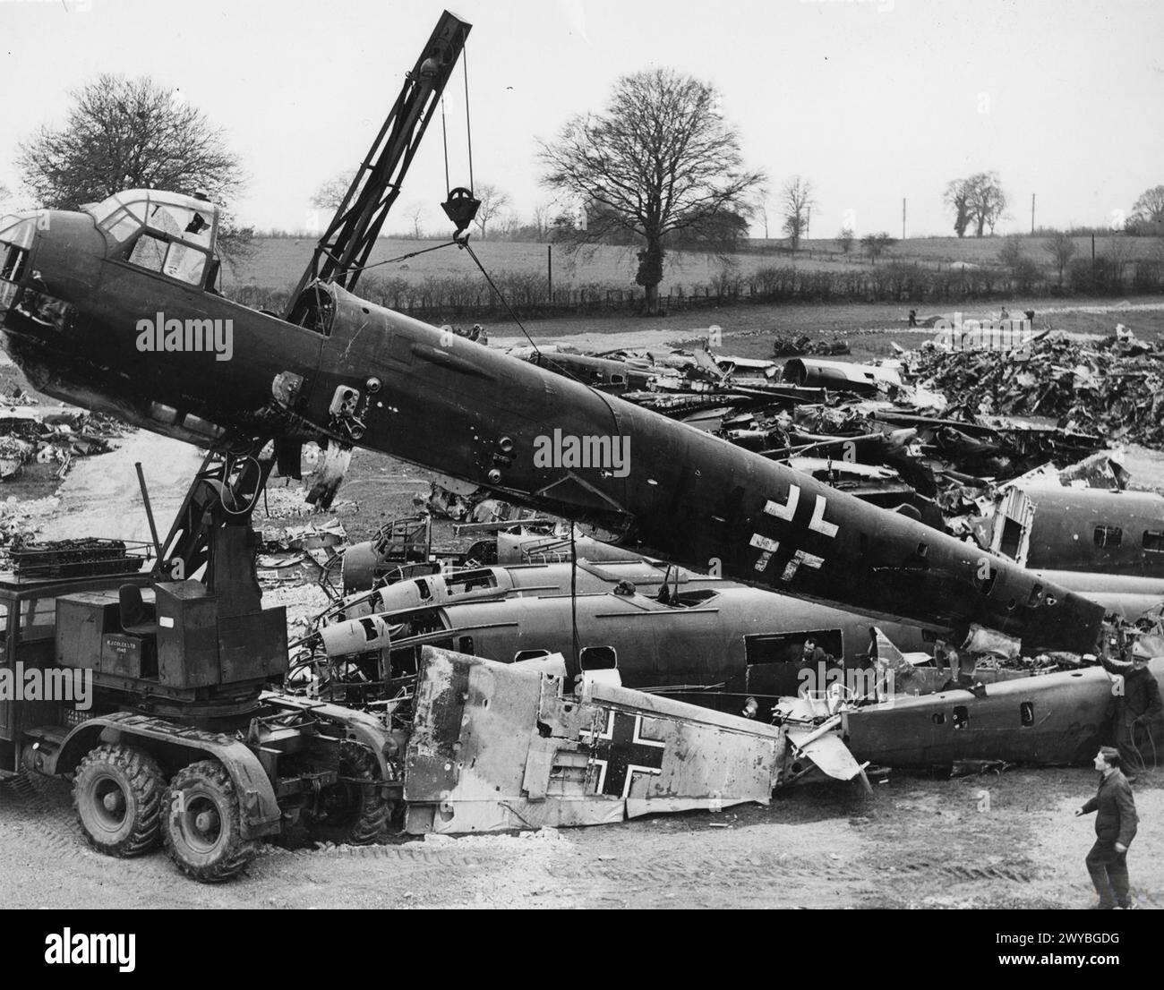 Relitti di aerei della Luftwaffe, tra cui una fusoliera Junkers Ju 88 sollevata da una gru, in un cantiere britannico, il 24 febbraio 1942. Foto Stock